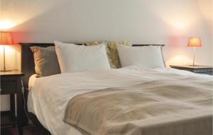 a large bed with white sheets and pillows at Nice Home In Leende With 3 Bedrooms And Wifi in Leende