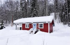 un cobertizo rojo cubierto de nieve en el bosque en Cozy Home In Sysslebck With House A Mountain View en Långav