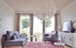 a living room with two chairs and a chandelier at Lovely Home In ngelholm With Outdoor Swimming Pool in Ängelholm