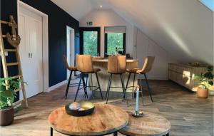 a living room with tables and stools and a kitchen at Stunning Apartment In Schagerbrug in Schagerbrug