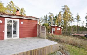 SundsandvikにあるNice Home In Henn With 2 Bedrooms And Wifiの赤い小さな建物の隣の木製デッキ