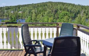 SvanskogにあるStunning Home In Svanskog With 3 Bedrooms And Wifiの湖の景色を望むデッキ(椅子3脚、テーブル付)