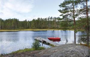 ein rotes Boot, das an einem Dock auf einem See parkt in der Unterkunft Lovely Home In Vegårshei With Sauna in Vegårshei + 15 Fotos