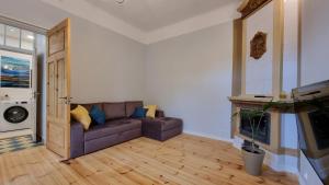 a living room with a couch and a tv at Aia Center Apartment with sauna in Pärnu