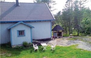 un edificio azul con 2 sillas y cenador en 3 Bedroom Cozy Home In Vatnestrm, en Oggevatn