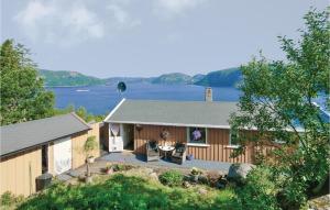 a house with a lake in the background at Nice Home In Farsund With Wifi in Farsund