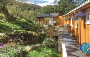a cottage with flowers and plants on the side of it at Nice Home In Farsund With Wifi in Farsund +21 photos