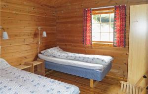 two beds in a log cabin with a window at Beautiful Home In Omastrand With Wifi in Oma