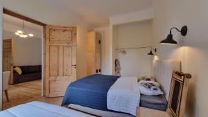 a bedroom with a bed with a blue blanket and a door at Aia Center Apartment with sauna in Pärnu