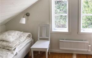 Stunning Home In Gislaved With Wifi في Askebo: غرفة نوم بسرير وكرسي أبيض