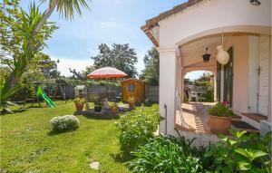 un patio con una casa con sombrilla y parque infantil en Amazing Home In Borgo With Kitchen en Borgo