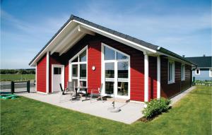 ein kleines rotes Haus mit einem Tisch und Stühlen in der Unterkunft Stunning Home In Dagebll With 2 Bedrooms, Sauna And Wifi in Dagebüll