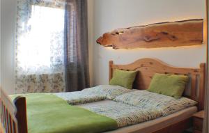 1 dormitorio con 1 cama con cabecero de madera y ventana en Awesome Apartment In Ertl With Wifi, en Buchschachen