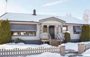 ビンメルビューにあるAwesome Home In Vimmerby With 3 Bedrooms And Saunaの雪の中の柵のある白い家