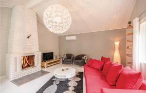 een woonkamer met een rode bank en een open haard bij 2 Bedroom Gorgeous Home In tran in Bälshult