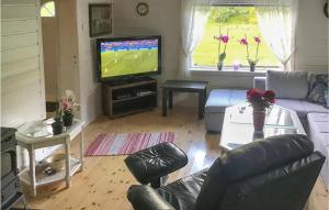 a living room with a couch and a television at Beautiful Home In Flekkefjord With 2 Bedrooms And Wifi in Flekkefjord