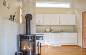 a kitchen with a stove in the middle of a room at 3 Bedroom Cozy Home In Forsand in Jørpeland