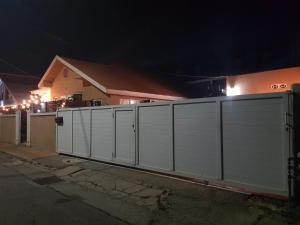 a white fence in front of a house at night at The Brayan's Apartment in Oranjestad