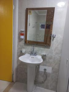 a bathroom with a sink and a mirror at The Brayan's Apartment in Oranjestad