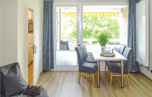 uma sala de jantar com uma mesa e cadeiras e uma janela em Lovely Apartment In Bsum With Kitchen em Büsum