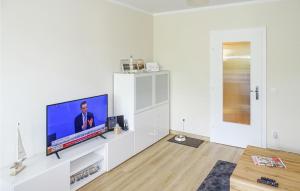 uma sala de estar com uma televisão de ecrã plano num armário branco em Lovely Apartment In Bsum With Kitchen em Büsum