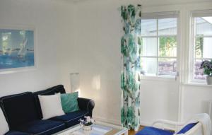 a living room with a blue couch and a window at 3 Bedroom Stunning Home In Bodafors in Bodafors