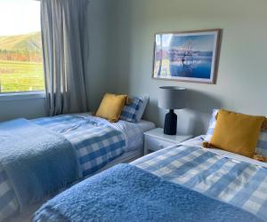 een slaapkamer met 2 bedden en een raam bij Fox Cottage in Ashwick Flat
