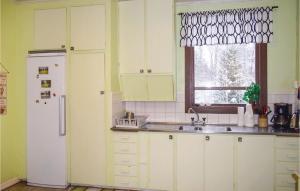 eine Küche mit einem weißen Kühlschrank und einer Spüle in der Unterkunft 3 Bedroom Awesome Home In lmhult in Älmhult