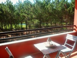 een balkon met een tafel, stoelen en bomen bij Apartamento Golf Resort in Charneca +10 foto's