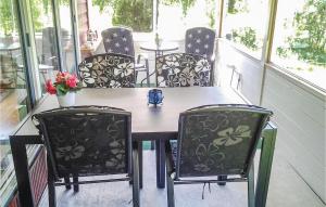 een tafel en stoelen op een veranda bij 2 Bedroom Lovely Home In ml in Ånimskog