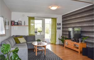 sala de estar con sofá gris y TV en Amazing Home In Grnna With Kitchen, en Gränna