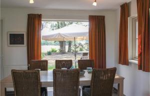 een eetkamer met een tafel met stoelen en een parasol bij Beautiful Home In Hoge Hexel With Kitchen in Hoge-Hexel