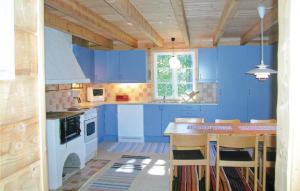 a kitchen with blue cabinets and a kitchen island with chairs at Beautiful Home In smo With 2 Bedrooms in Ösmo