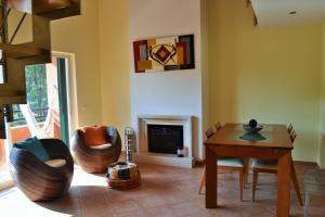 a living room with a fireplace and a table and chairs at Apartamento Golf Resort in Charneca