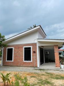 a brick house with a garage at Cabin in the Woods by Abris in Bukit Gambir