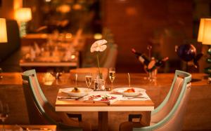 a wooden table with two plates of food on it at Titanic Deluxe Lara in Lara