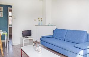 a living room with a blue couch and a tv at De Eekhof - Appartement Tuin in Hindeloopen
