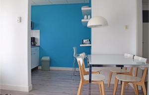 cocina con paredes azules, mesa y sillas en De Eekhof - Appartement Tuin, en Hindeloopen