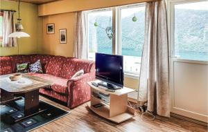uma sala de estar com um sofá vermelho e uma televisão em Ytre Matre em Ytre Matre