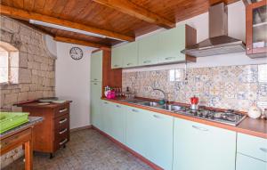 a kitchen with white cabinets and a sink at Awesome Home In Modica With House Sea View in Modica