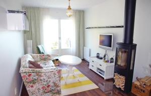 - un salon avec un poêle à bois et une chaise dans l'établissement Cozy Home In Klssbol With Kitchen, à Rolfsbol