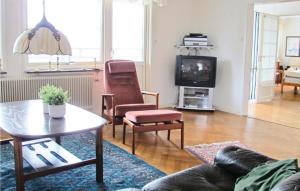 a living room with a couch and a table and a tv at Amazing Home In Lysekil With 4 Bedrooms, Sauna And Wifi in Lysekil