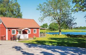 FågelmaraにあるStunning Home In Fgelmara With 2 Bedrooms And Wifiの木と湖のある赤い家