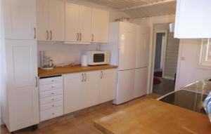 kuchnia z białymi szafkami i kuchenką mikrofalową w obiekcie Gorgeous Home In Flen With Sauna w mieście Flen