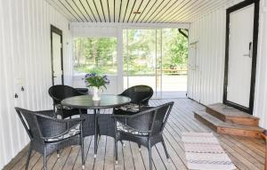 uma sala de jantar com uma mesa e cadeiras num alpendre em Beautiful Home In Sffle With Kitchen em Säffle