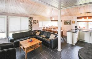 salon z czarną skórzaną kanapą i stołem w obiekcie 3 Bedroom Stunning Home In Sjusjen w mieście Sjusjøen