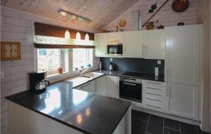 a kitchen with white cabinets and a black counter top at 3 Bedroom Stunning Home In Sjusjøen in Sjusjøen +9 photos