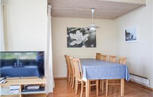 a dining room with a blue table and a tv at Nice Home In Nedstrand With 5 Bedrooms, Sauna And Wifi in Nedstrand