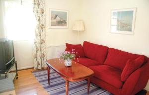 a living room with a red couch and a table at Villa Skogshem in Visby
