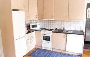 a kitchen with white appliances and a white microwave at Villa Skogshem in Visby